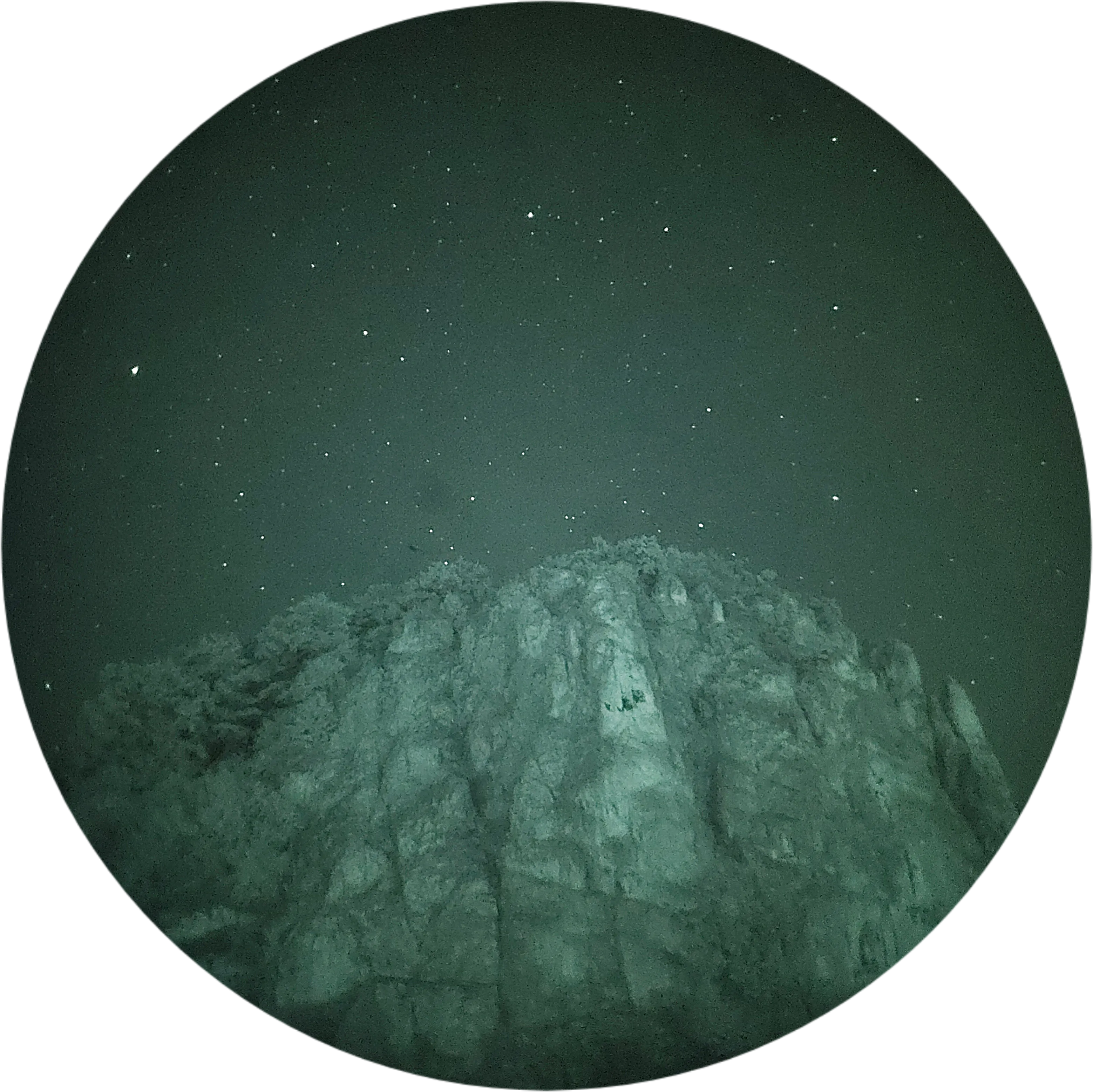 Silhouette of a mountain peak against the stars in night vision