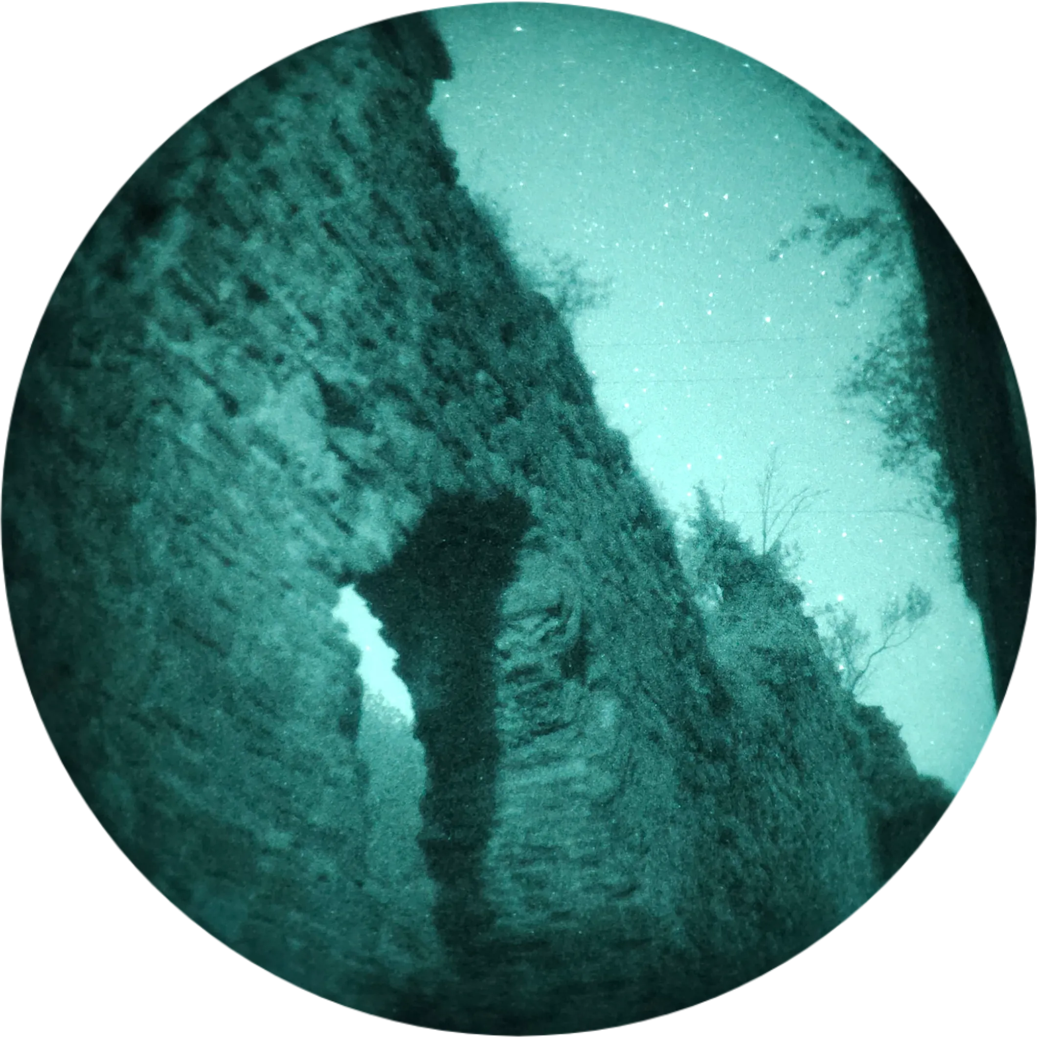 Stone archway beneath a starry sky, seen in night vision