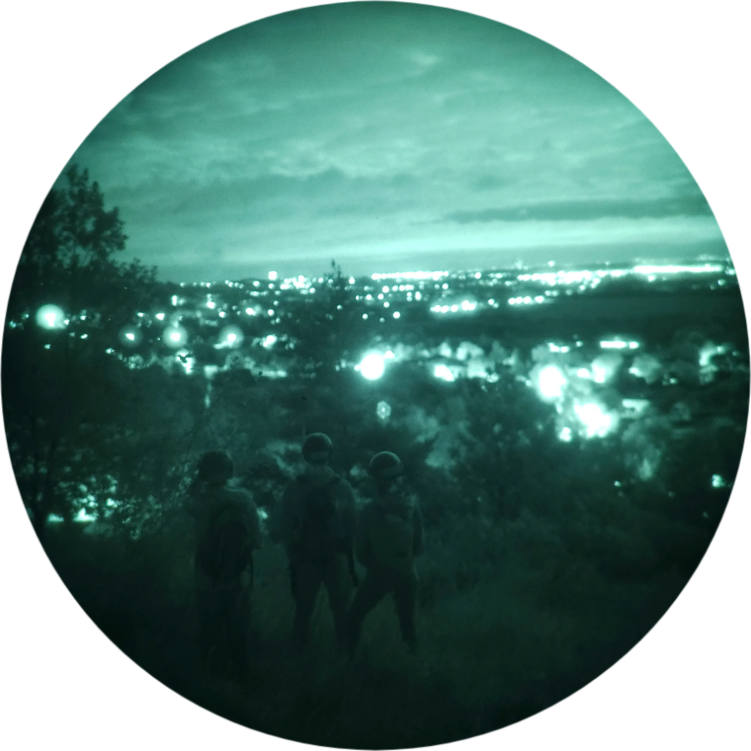 Group of trip participants on a ridge overlooking city lights at dusk